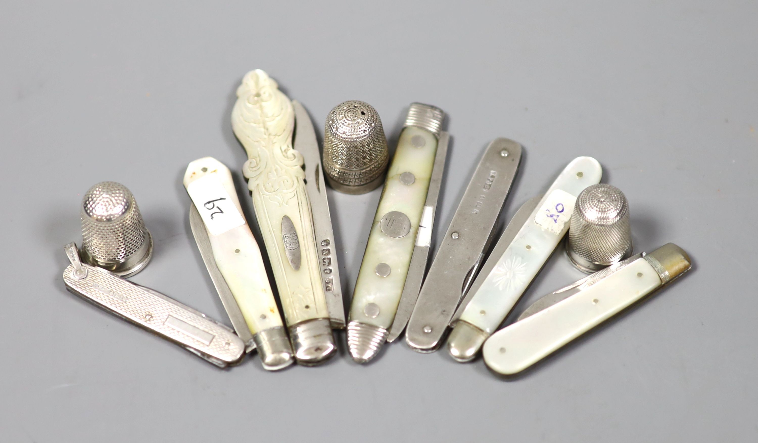 Seven assorted mother of pearl handled silver fruit knives and a penknife and three silver thimbles.
